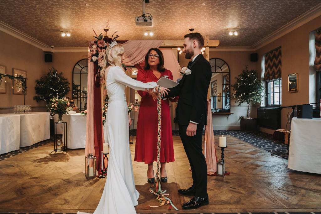 Winter wedding ceremony under a floral arch