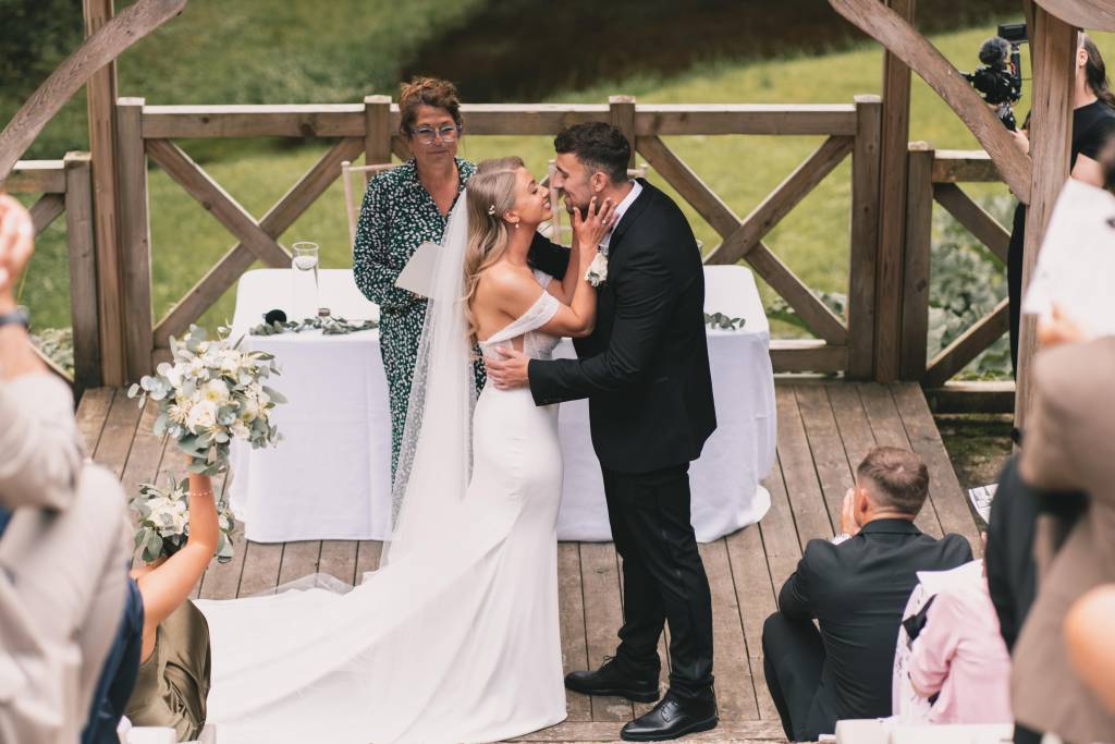 First kiss at an outdoor deck wedding ceremony