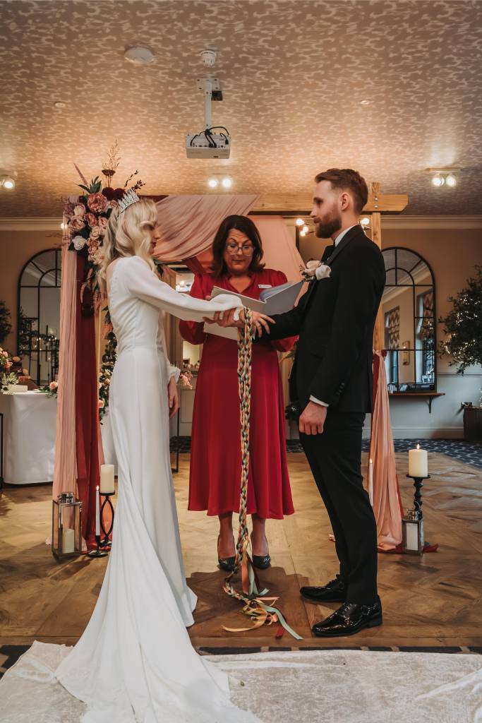 Jane Jones leading a handfasting ritual during a celebrant-led wedding ceremony
