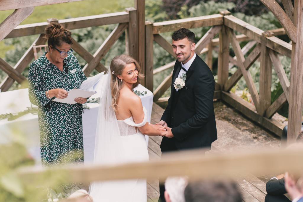 Couple exchanging vows on an outdoor wooden deck