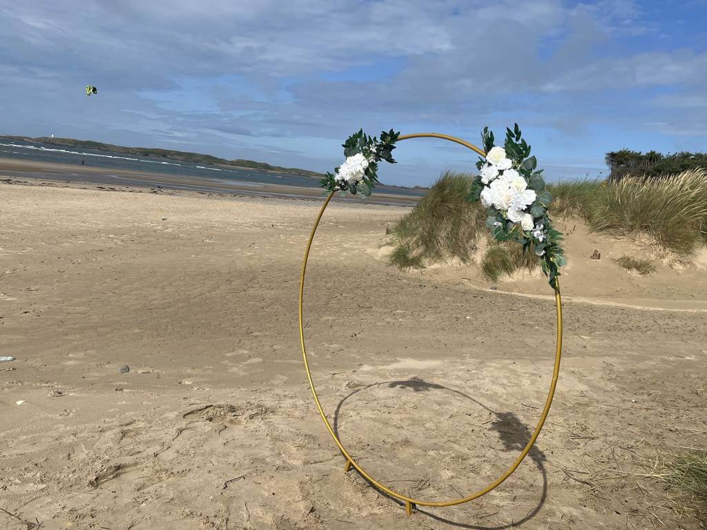 Floral wedding hoop on a sandy North Wales beach
