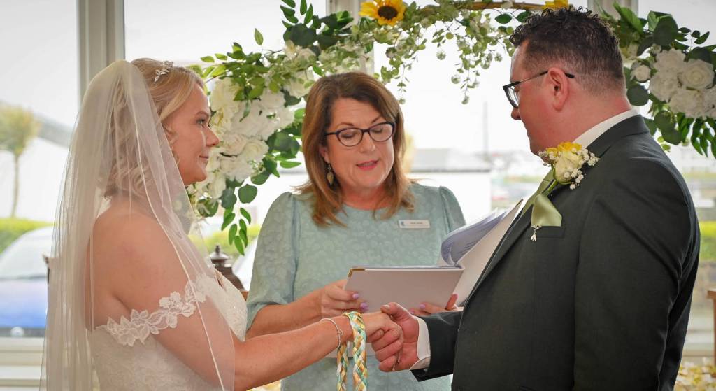 Jane Jones leading a wedding ceremony for a bride and groom
