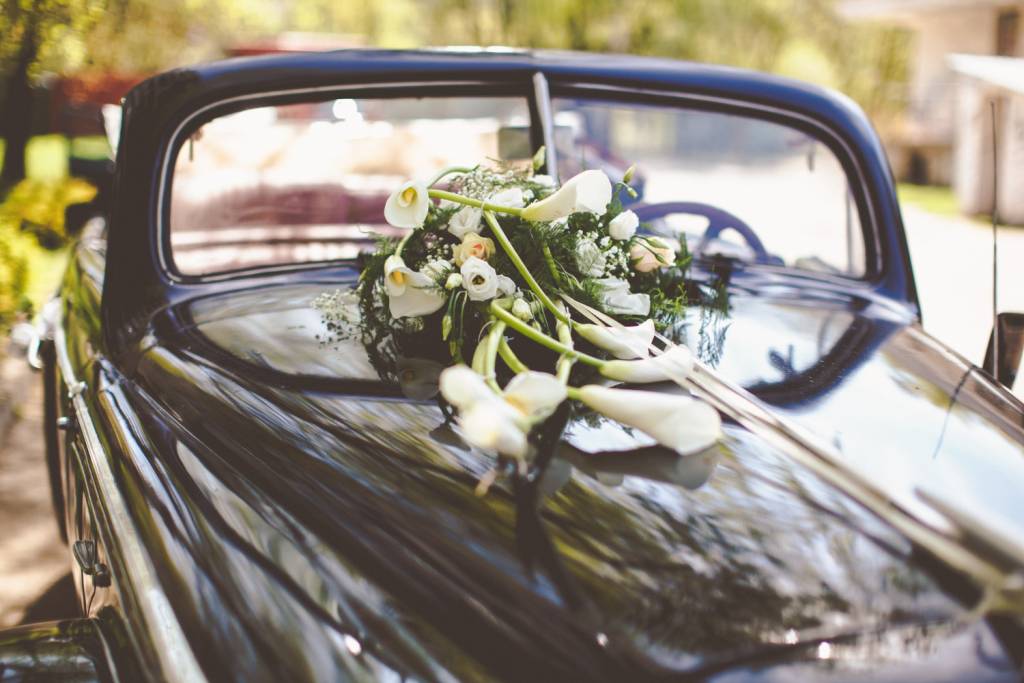 Classic wedding car decorated with white flowers