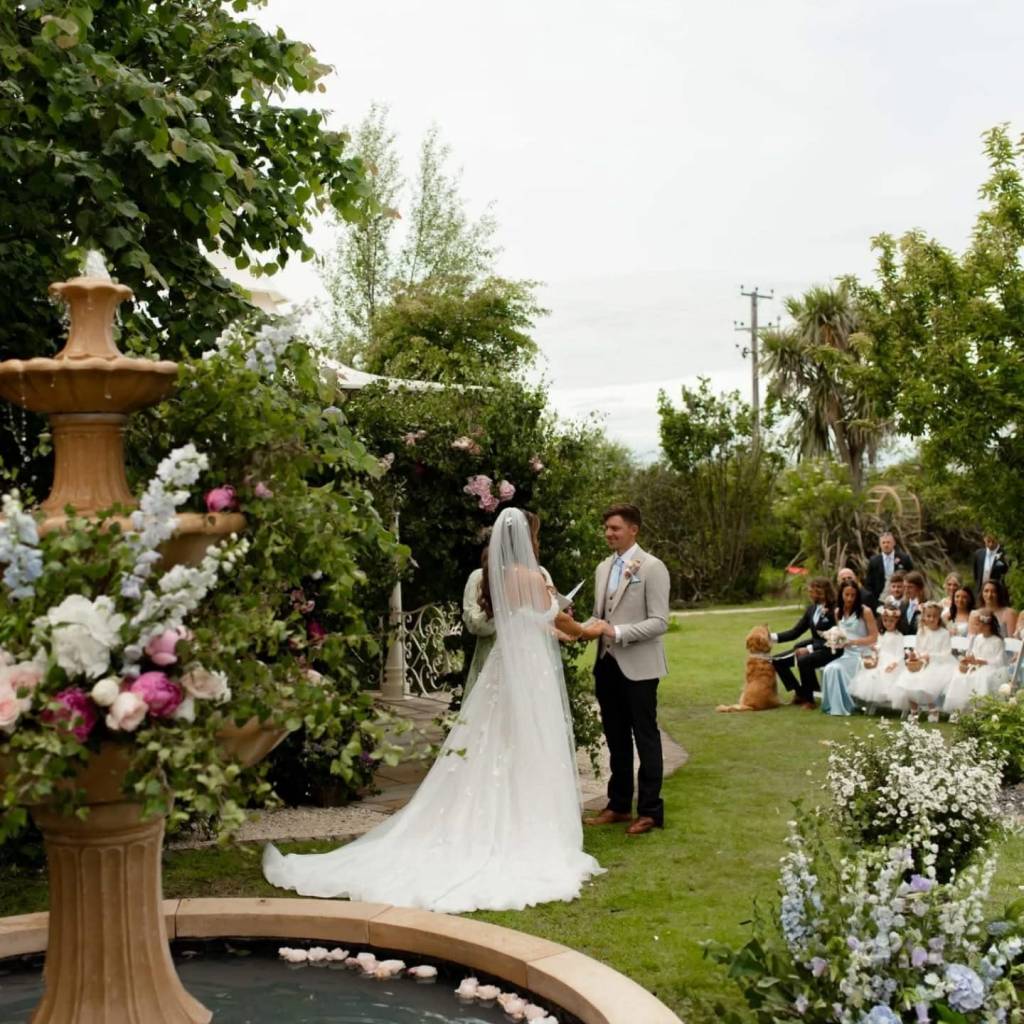Outdoor garden wedding ceremony in North Wales with guests seated on the lawn